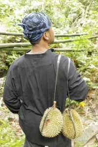 Pria Baduy berikat kepala membawa dua durian di pundak