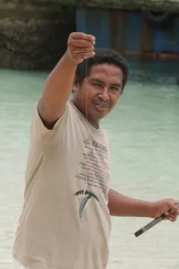 Pria memamerkan hasil pancingan di pantai Ambon