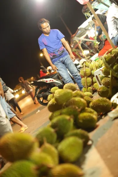 Pedagang durian di lapak pinggir jalan pada malam hari